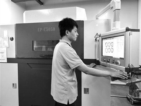 西安康拓医疗技术有限公司工程师查看3D打印设备工作情况 新华社发